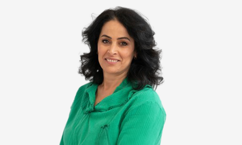 Foto van Saida Youssef in een groene trui voor een witte achtergrond