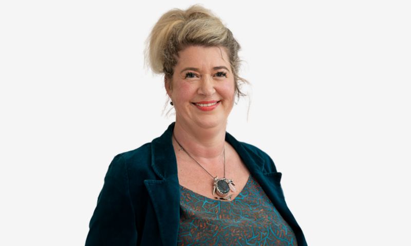 Foto van Femke Molenaar in een donkerblauwe blazer en groen shirt voor een witte achtergrond