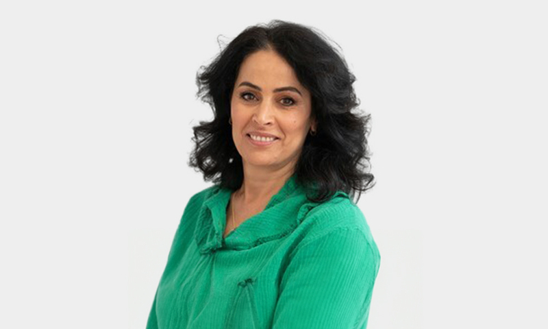 Foto van Saida Youssef in een groene trui voor een witte achtergrond